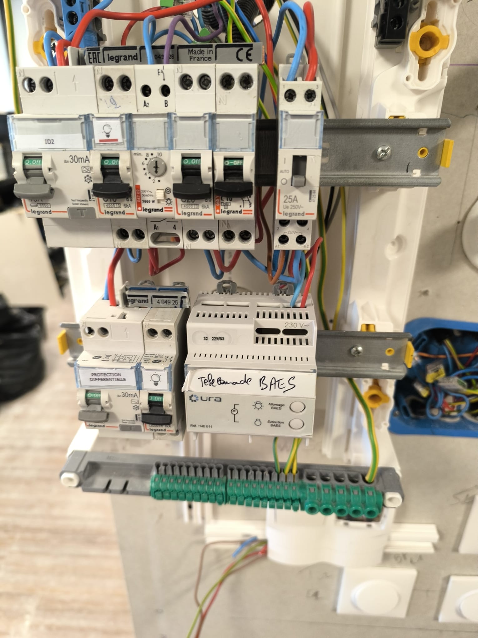Tableau électrique ouvert, avec les modules de protection et les conducteurs en cours de câblage